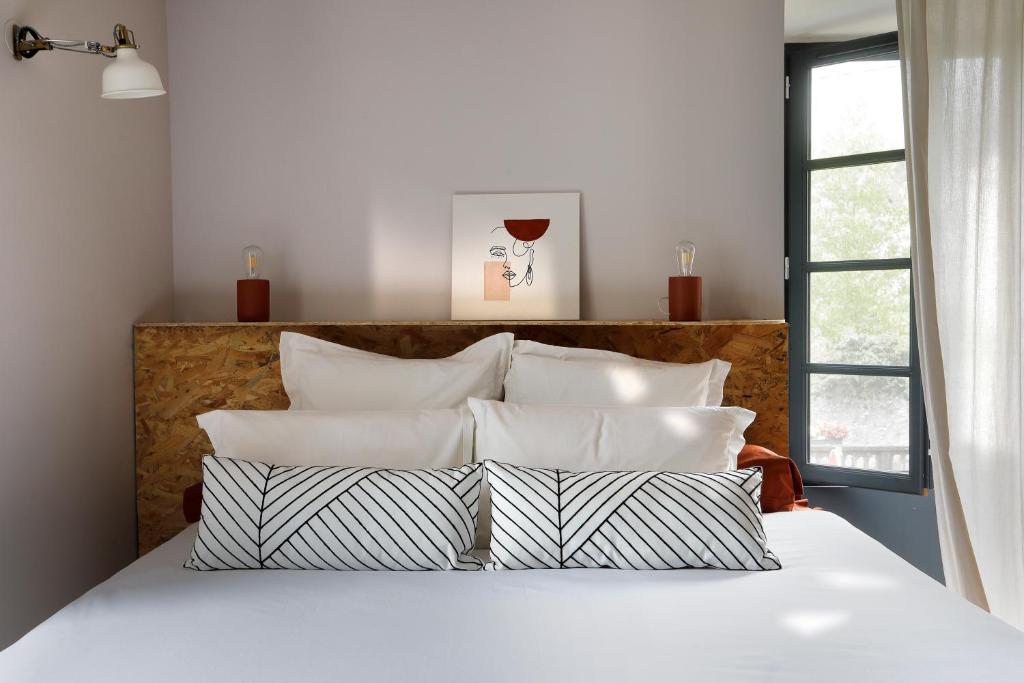 BielleMaison Lavillete的一间卧室配有带白色床单和枕头的床。