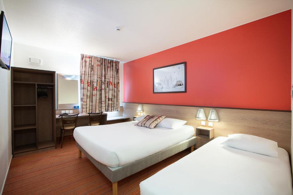 贝利罗曼维利而巴黎马恩河谷Ace酒店的酒店客房设有两张床和红色的墙壁。