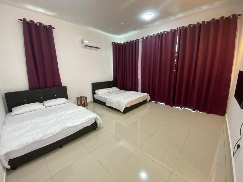 马六甲KSP Guest House的配有红色窗帘的客房内的两张床
