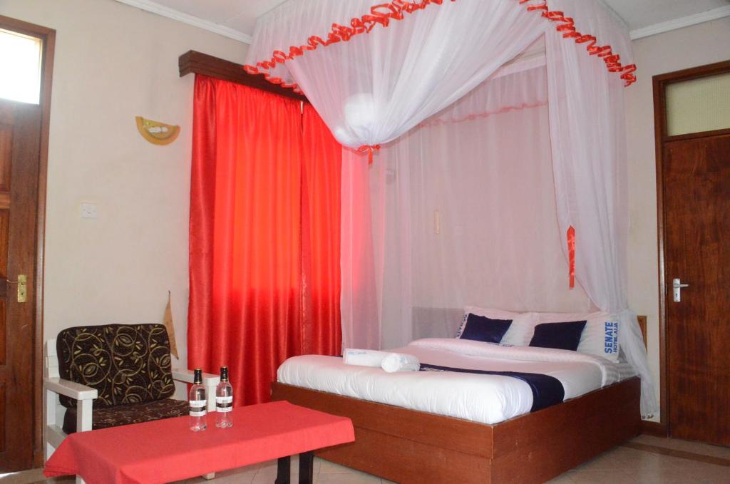 ThikaHOTEL SENATE JUJA的一间卧室配有床和红色窗帘