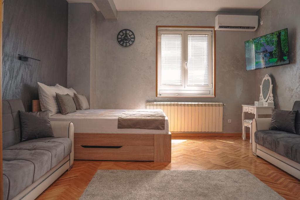 弗尔尼亚奇卡矿泉镇Dukat Apartmani-Studio的客厅配有床和沙发