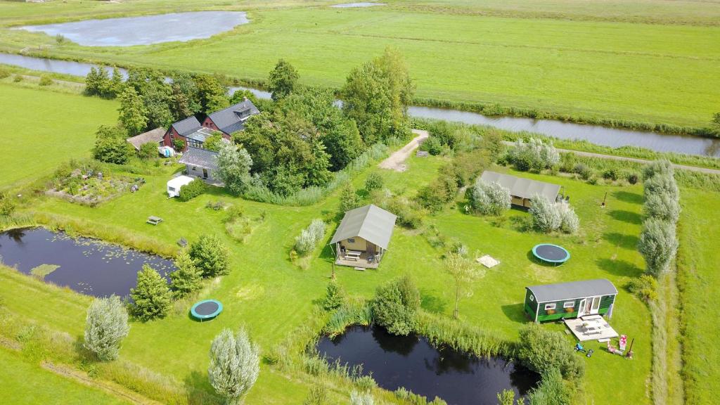 LettelbertSafaritent Lisdodde的享有农场的空中景色,拥有一组房屋和水