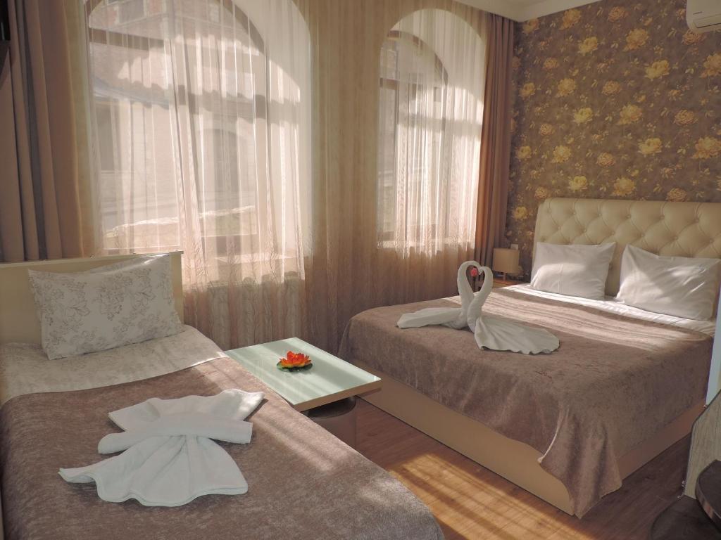 阿哈尔齐赫Hotel Lotus的一间卧室配有两张床和白色毛巾。