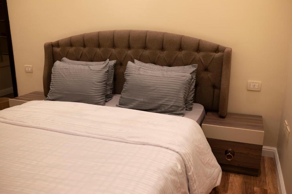 开罗Munir’s residence的卧室配有一张带白色床单和枕头的大床。