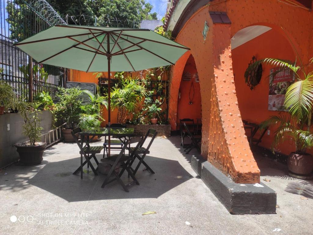 萨尔瓦多Pousada San Salvador的大楼前的桌椅和遮阳伞