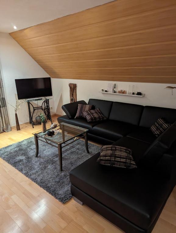 施马伦贝格Ferienwohnung Soreth的客厅配有黑色沙发和电视