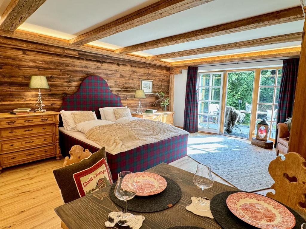 基茨比厄尔Mountain Suites by Belle-Stay的一间卧室配有一张床和一张带酒杯的桌子