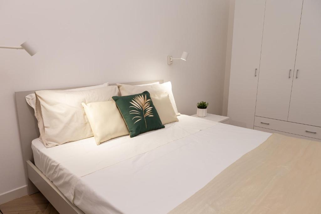 维拉西米乌斯Estia Suites的一张带三个枕头的白色床