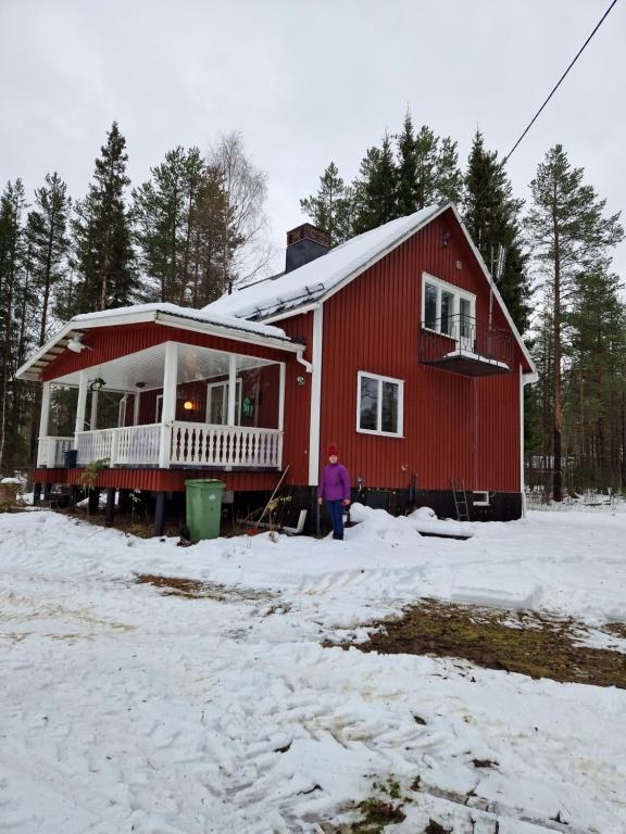 JockÖverkalix Kalixalven Lodge Jockfall的站在雪中红房子前面的人