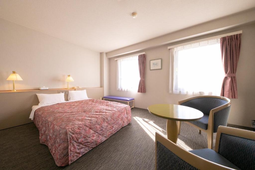 都城市Main Hotel - Vacation STAY 85438v的酒店客房设有床、桌子和窗户。