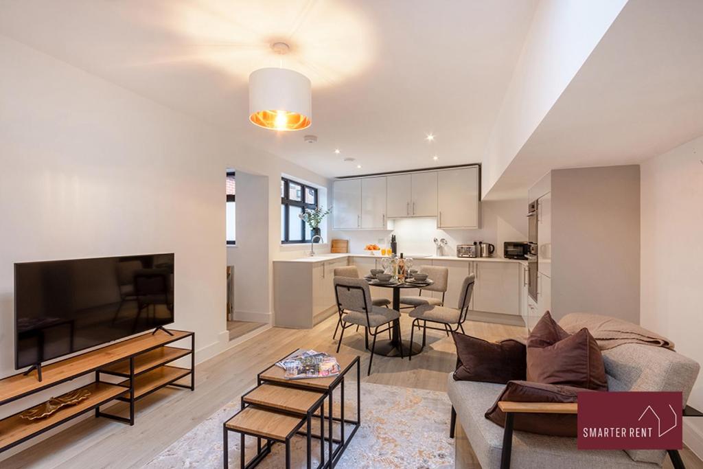 沃金厄姆Modern 3 Bedroom Apartment - Wokingham的带沙发和电视的客厅以及厨房。