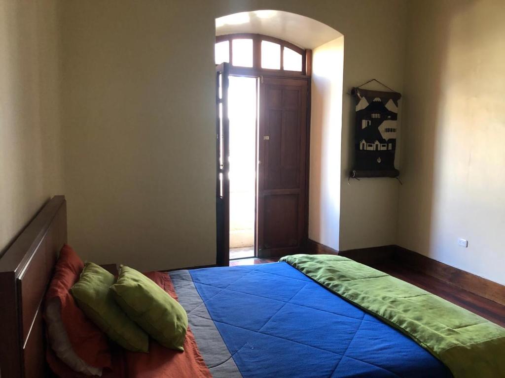 里奥班巴HOSPEDAJE las PRIMICIAS RIOBAMBA 105的一间卧室配有一张带蓝色棉被的床
