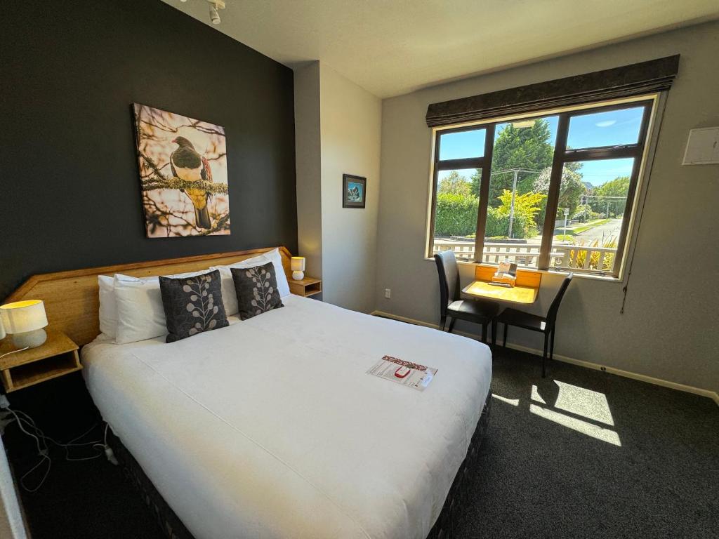 奥阿库尼斯诺哈文酒店的一间卧室配有一张床、一张书桌和一个窗户。