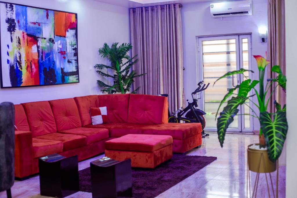 AbeokutaÌtùnú at Molara's Villa的客厅配有红色沙发和植物