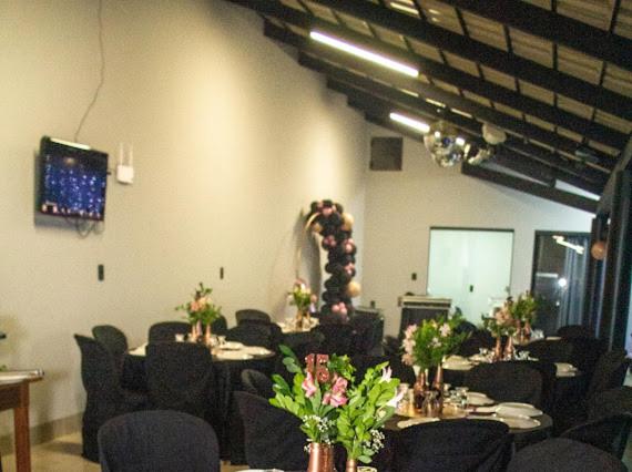 乌贝拉巴Casa de lazer km eventos的一间设有桌椅和鲜花的会议室