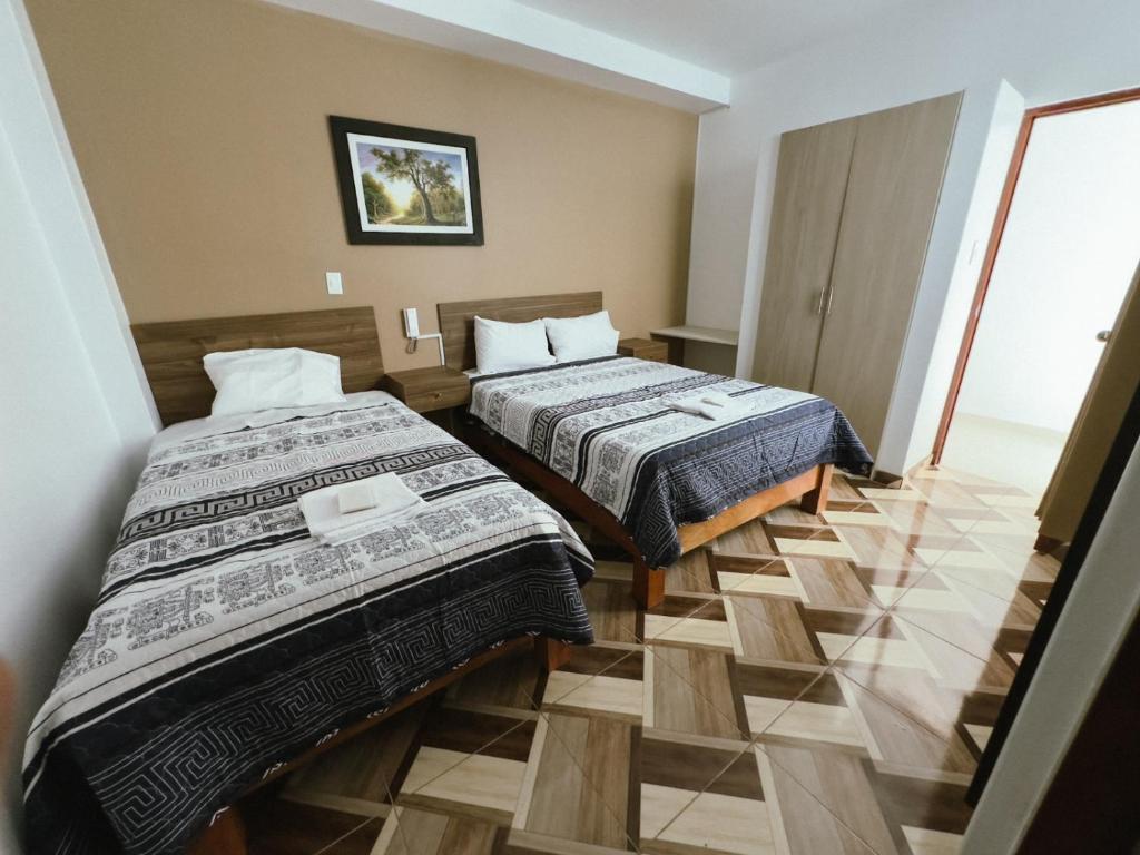 卡哈马卡HOTEL NILA的酒店客房 - 带两张床和瓷砖地板