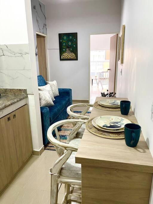 卡利BRR LIMONAR - Nuevo, Cómodo y hermoso aparta estudio 301的厨房配有两把椅子和一张桌子及盘子