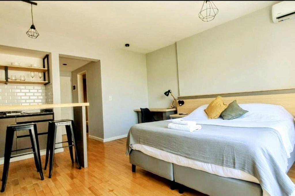 萨尔塔Caseros Suite!! Hermoso Apart en Corredor turistico de Salta!!的一间卧室配有一张大床和一张书桌