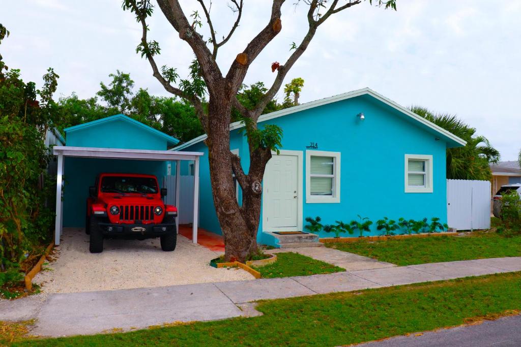 达尼亚滩Caribbean Style House的一辆蓝色的房子,前面停着一辆吉普车