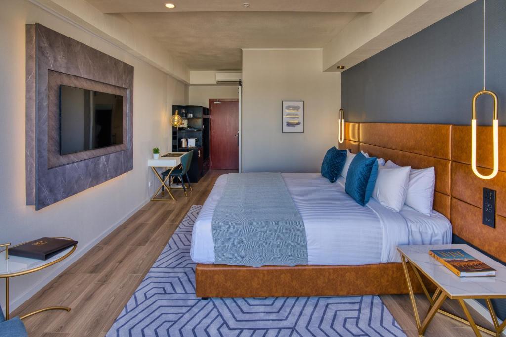 奥克兰SOHO Hotel Auckland的酒店客房设有一张大床和一张书桌。