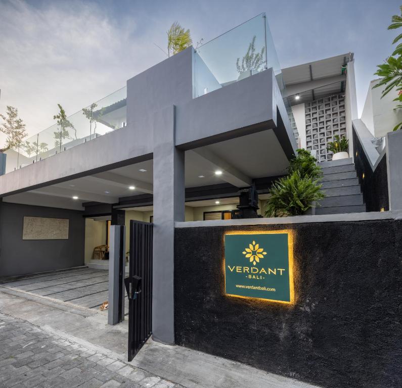 登巴萨Verdant Bali Sekar Sari的一座现代房子,前面有黄色标志