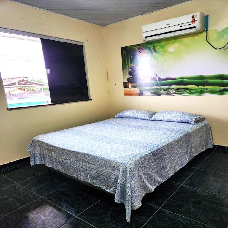 布雷夫斯Hotel & Residencial Marajoara的卧室配有一张床,墙上挂着一幅大照片