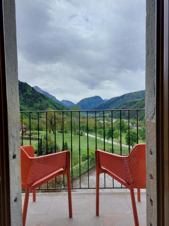 阿尔塔泰尔梅Residence Samont的阳台上配有两把红色椅子,享有美景