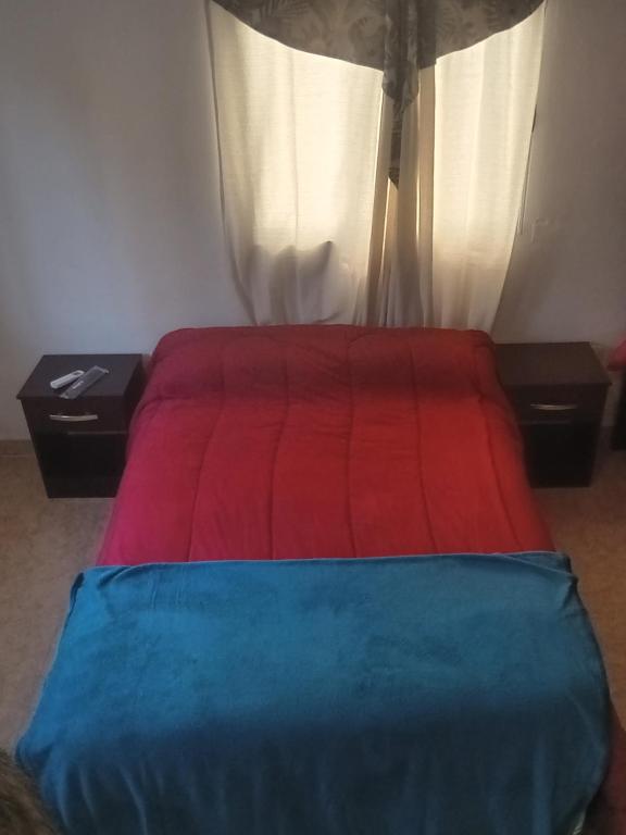 卡塔马卡Alquiler Temporario Catamarca的一间卧室配有一张带红色和蓝色毯子的床
