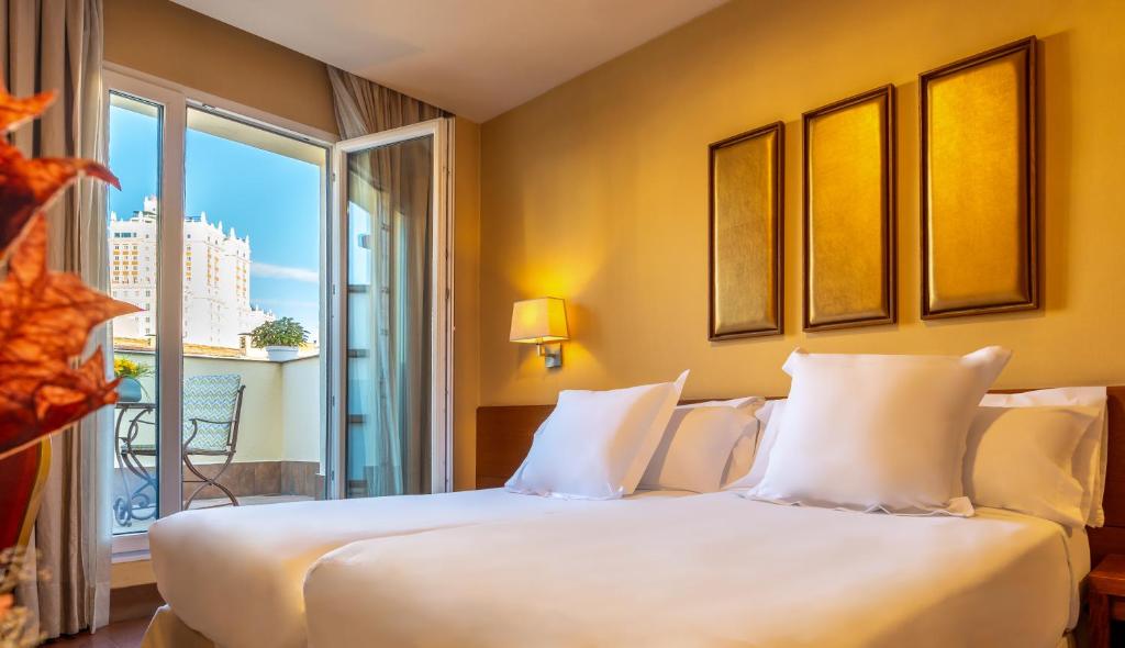 马德里斯特林酒店的卧室设有一张白色大床和一扇窗户。