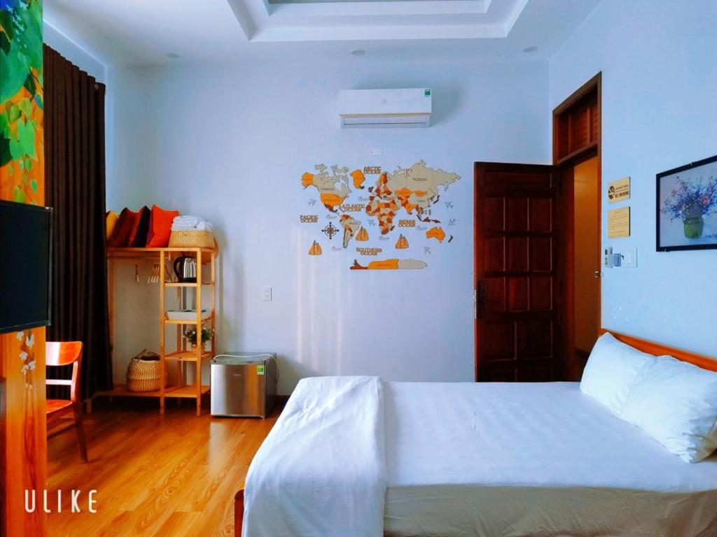 归仁Việt Homestay Quy Nhơn的一间卧室配有一张床,墙上贴有地图