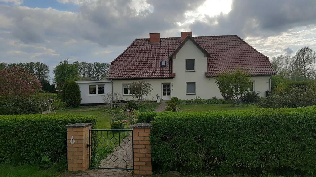 SabelFerienwohnung im Zanderhaus的白色的房子,有红色的屋顶和栅栏