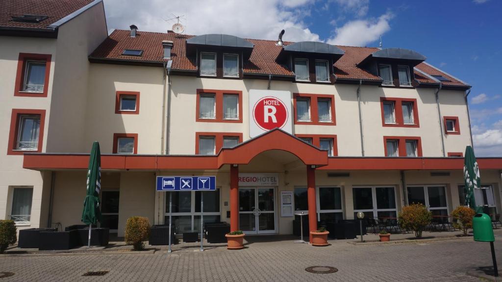 施科伊迪茨REGIOHOTEL Leipzig West的一座白色的大建筑,有红色的屋顶