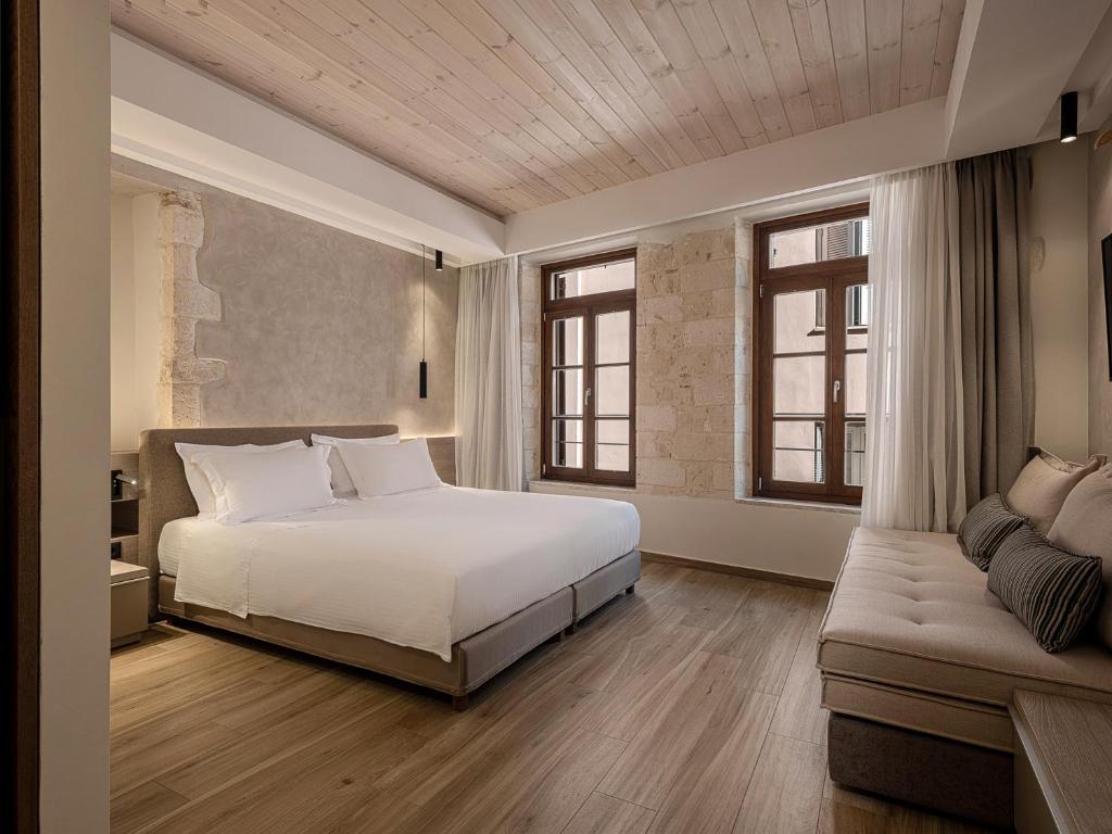 干尼亚CASA DORINI的卧室配有白色的床和沙发