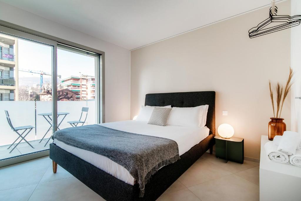 MassagnoKristall 9 by Quokka 360 - modern apartment close to Lugano Center的一间卧室设有一张床和一个阳台