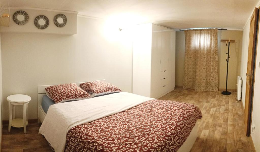 阿纳齐Paisible appartement proche des 24h et du lac的一间卧室配有红色和白色床单