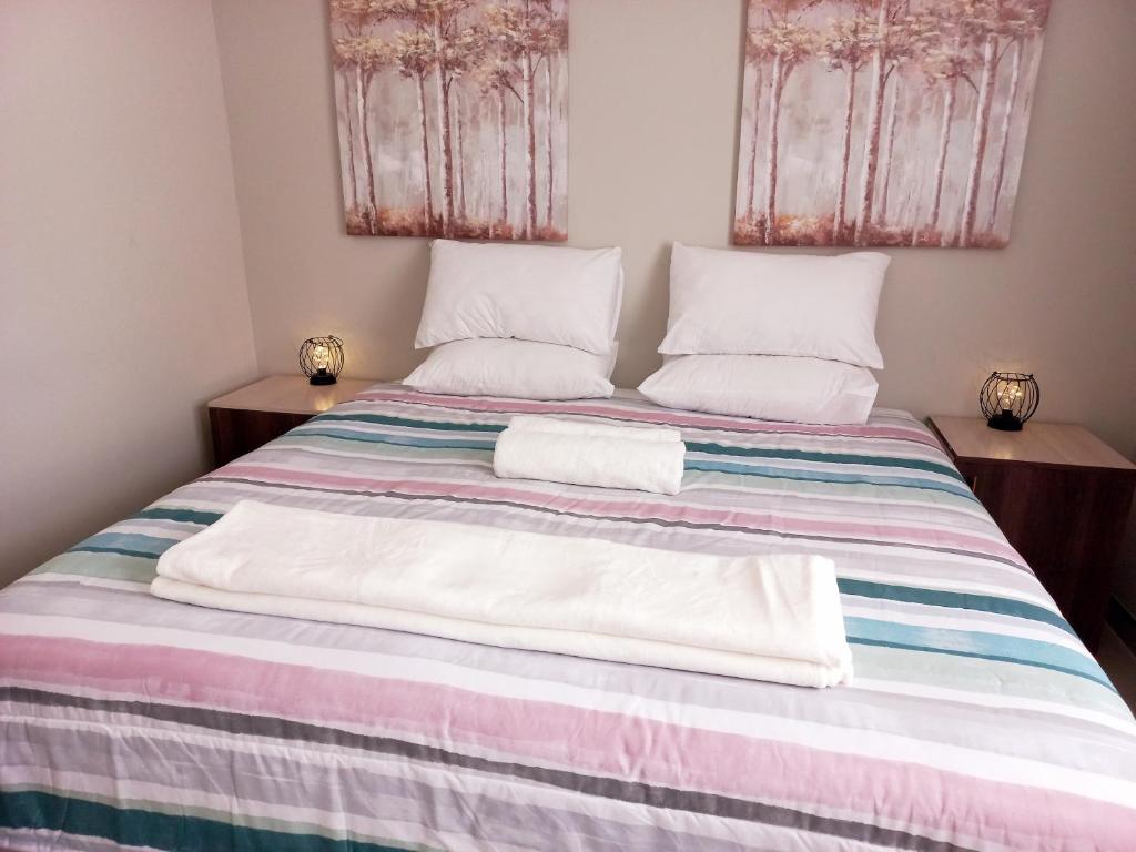 鲸湾港TALITHA'S SELF-CATERING ACCOMMODATION的一间卧室配有一张床,上面有两条毛巾