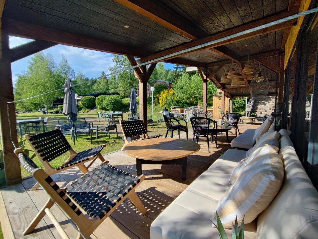 Le BleymardLes Chalets Du Goulet的庭院配有椅子、沙发和桌子