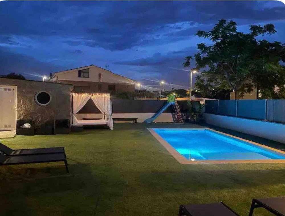 比利亚努埃瓦-赫尔特鲁Acogedora casa con piscina y 3 dormitorios的后院,晚上设有游泳池