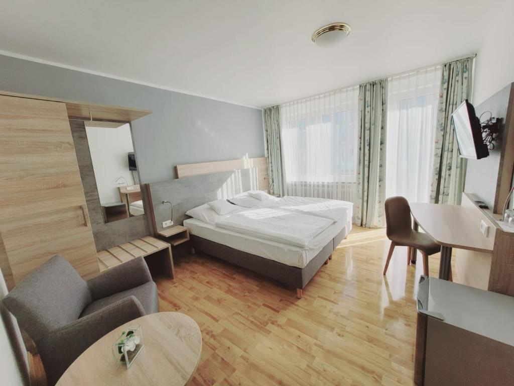 波恩Hotel Europa的一间卧室配有一张床、一张沙发和一张桌子