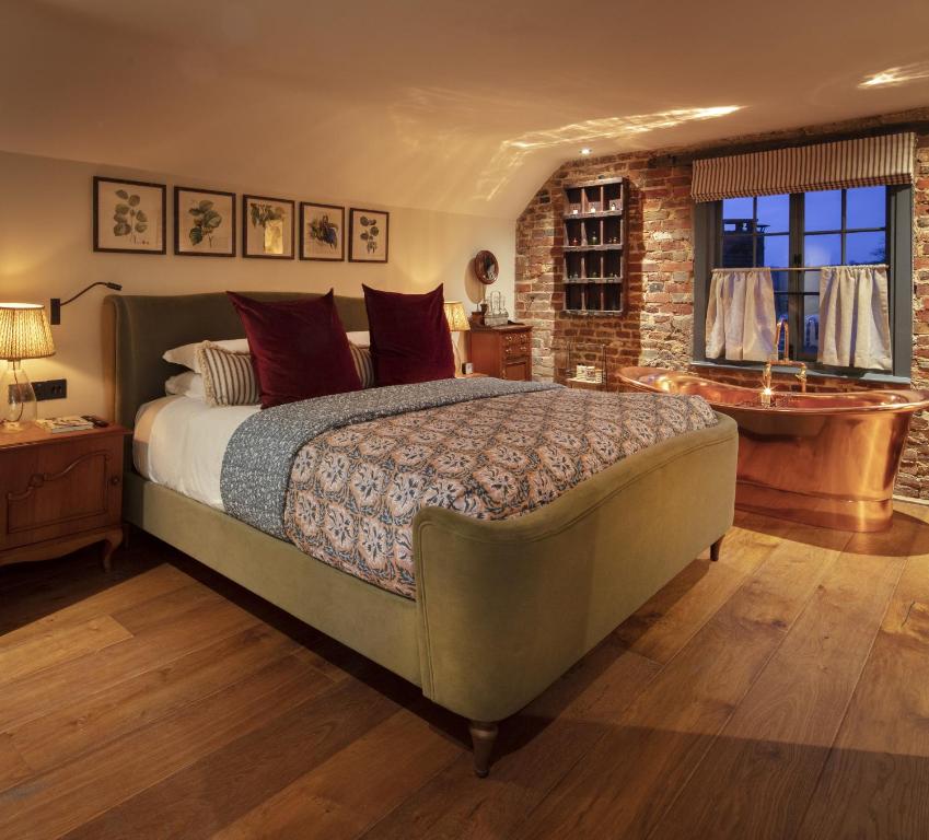PenshurstThe Leicester Arms Country Inn的一间卧室设有一张大床和砖墙