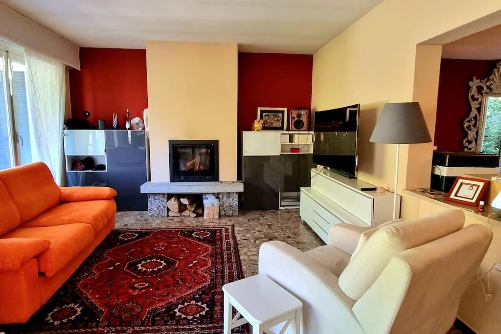 PurascaHaus Sonnenschein的客厅配有橙色和白色家具和壁炉