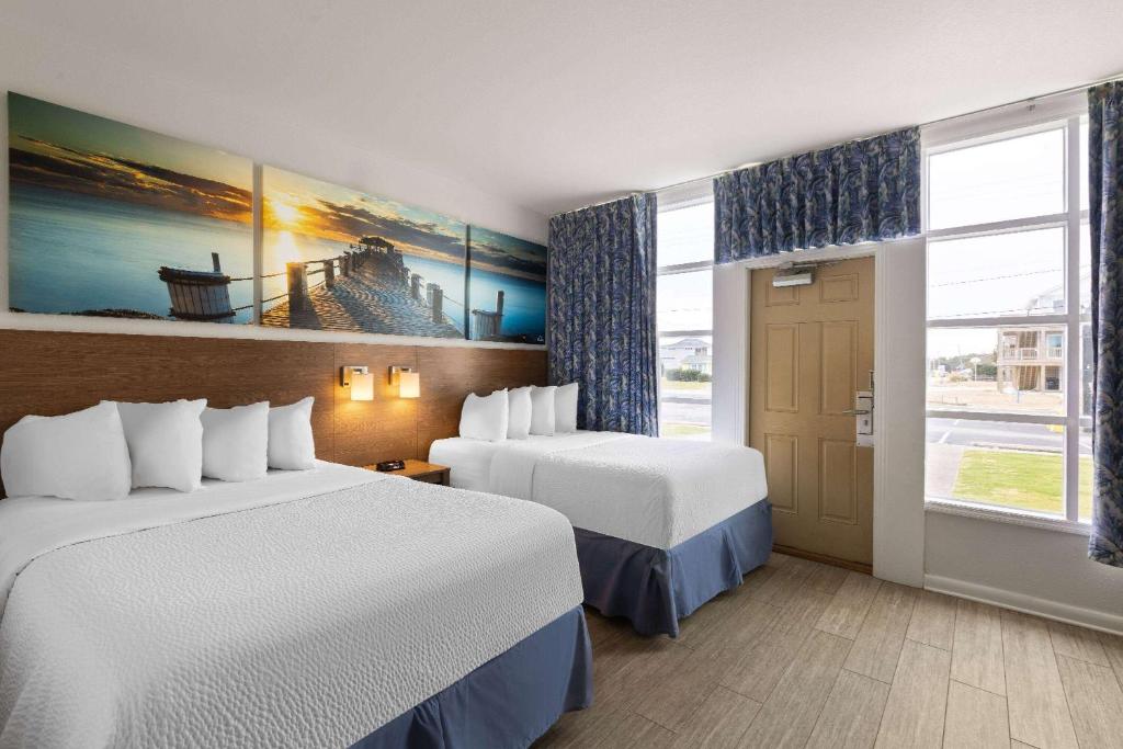 斩魔山威尔伯斩魔山海滨戴斯酒店的酒店客房设有两张床和窗户。