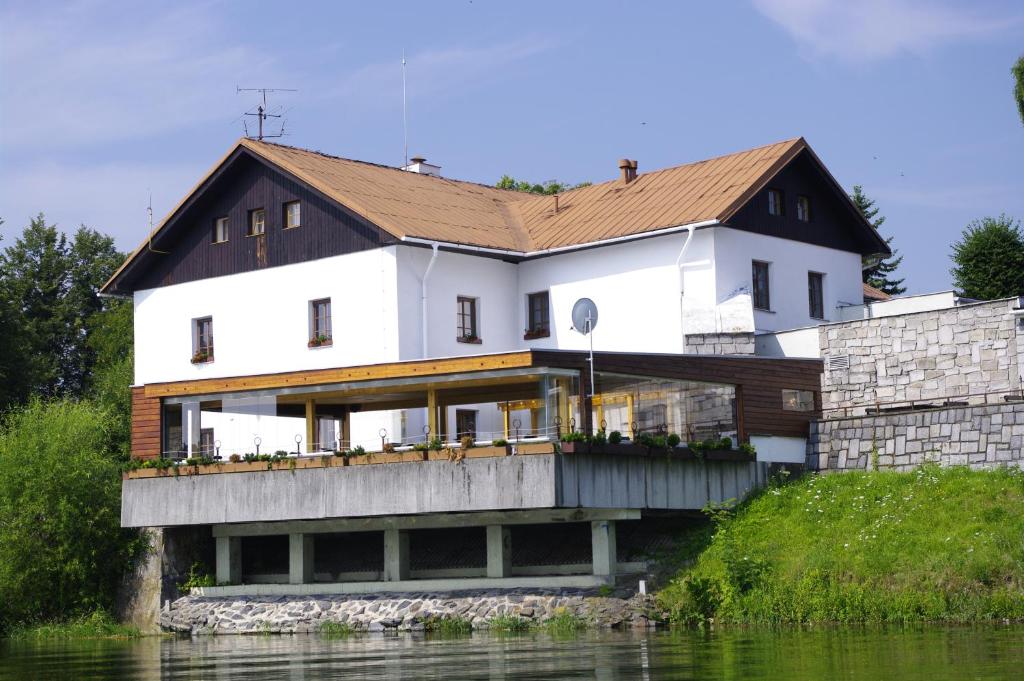 Horní TěrlickoHotel Jaškovská Krčma的河边的白色大房子