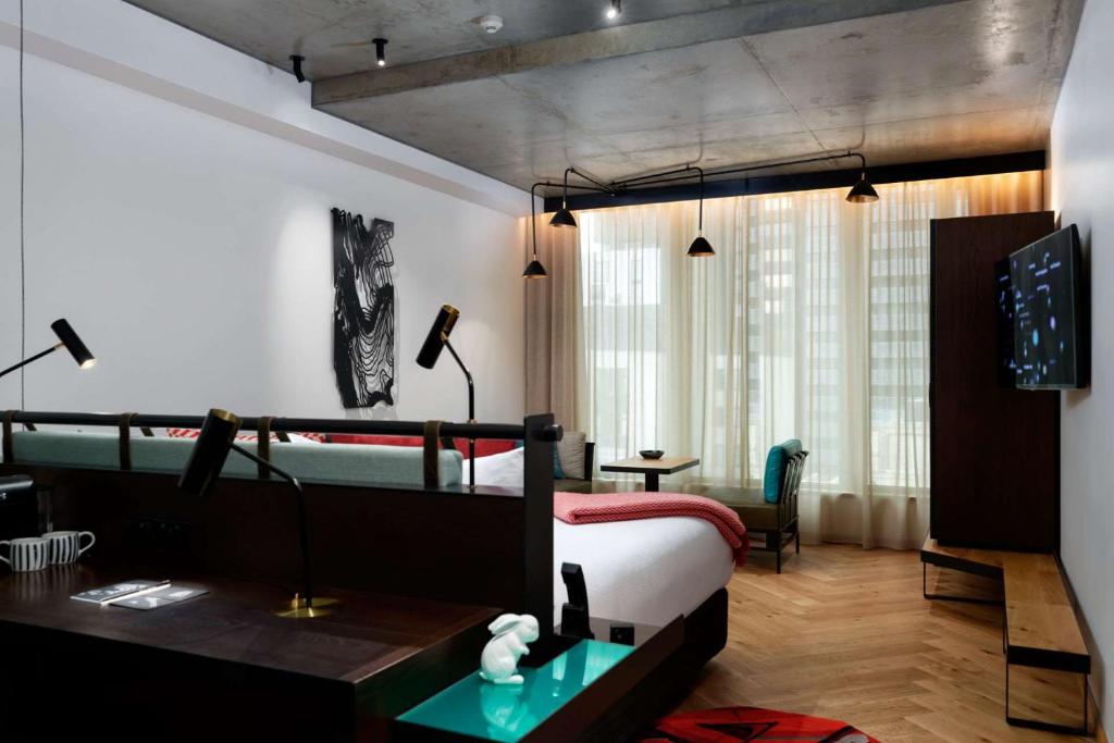 墨尔本墨尔本QT精品酒店的一间酒店客房,一间设有一张床和一张书桌