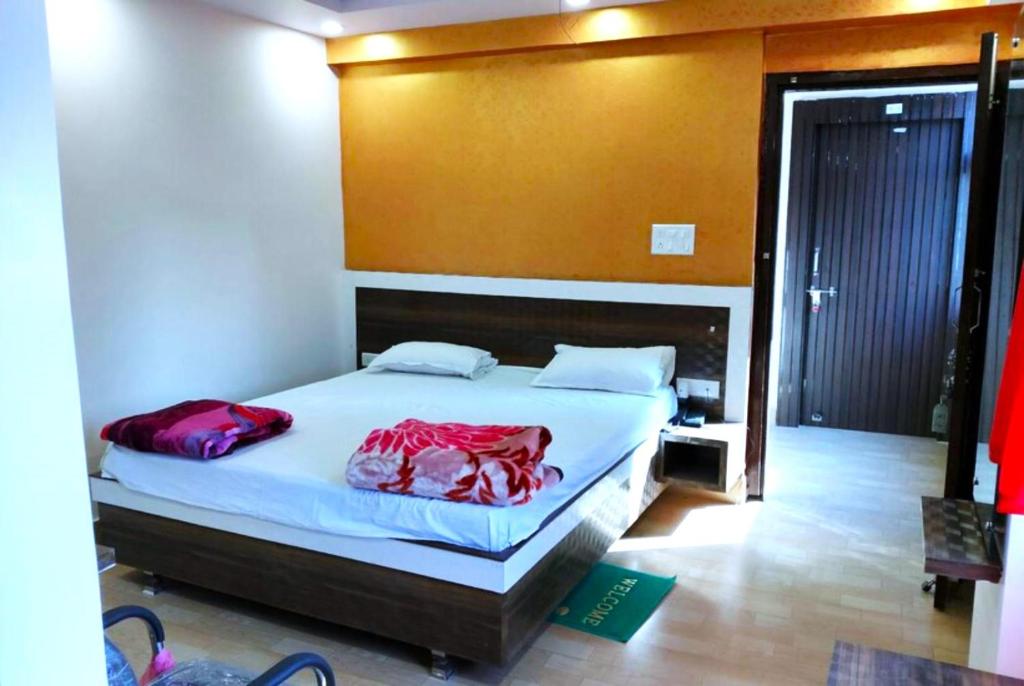 巴特那Goroomgo Mayagiri Patna的一间卧室配有红色床单
