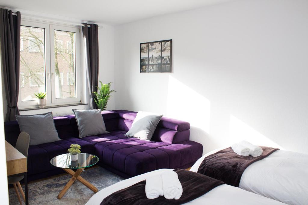 不莱梅Timeless Apartment Bremen-Neustadt的客厅配有紫色沙发和桌子