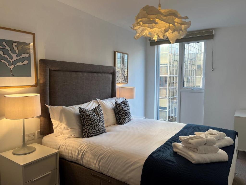 南安普敦Southampton City Apartments by Charles Hope的一间卧室配有一张大床和毛巾