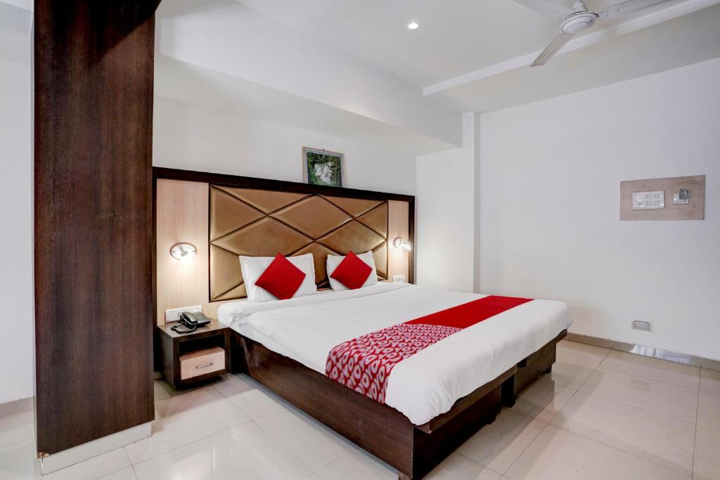 孟买Super OYO Flagship Hotel Everest Lodging Vashi的一间卧室配有一张带红色枕头的大床