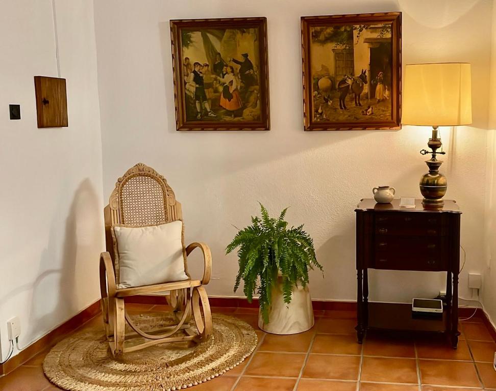 Casa de pueblo Ca Barret, a tan sólo dos kilómetros de Xàtiva的一间房间,里面摆放着椅子和植物,墙上挂着图片