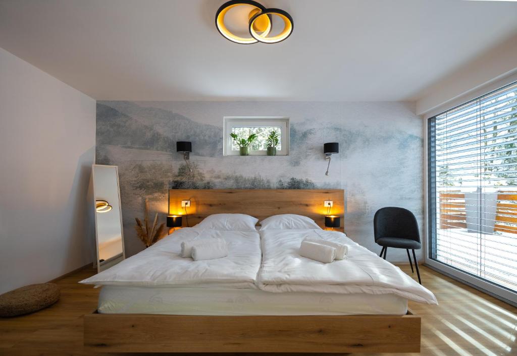 戈德马图杰克Hiša Zima的卧室设有一张大白色的床和大窗户